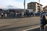 コンビニエンスストアの後ろにそびえる富士山を背景に、写真撮影する外国人観光客ら＝山梨県富士河口湖町船津で2024年4月25日、野田樹撮影
