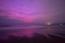 オーロラの影響でピンクに染まる空と、その光を映すオホーツク海。右は知床半島（20秒間露光）＝北海道斜里町で2024年5月11日午後11時34分、貝塚太一撮影