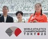 東京で開催される陸上世界選手権の大会ロゴを手にする中川亮さん（左）、女子やり投げの北口榛花（右）ら＝東京・国立競技場で2024年5月13日