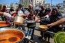 支援団体から食事を受け取ろうとする人たち＝パレスチナ自治区ガザ地区最南部ラファで2024年5月8日、ロイター