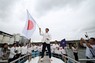 パリ五輪の開会式でパレードする船の上で日の丸を掲げる日本の旗手、半井重幸選手＝パリで2024年7月26日、ロイター
