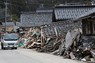 能登半島地震と津波で大きな被害を受けた石川県珠洲市鵜飼地区。道路脇にはがれきが積まれたままになっている＝2024年2月29日、大西岳彦撮影