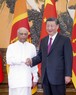 スリランカのグナワルダナ首相（左）と握手する中国の習近平国家主席＝北京の人民大会堂で27日、新華社・共同