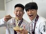 成田空港に帰国し、大好物のうどんを手に笑顔の日下尚（左）。右は17歳でアジア選手権優勝の快挙を成し遂げた後輩の吉田泰造