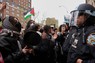 パレスチナ旗を掲げる学生らとにらみ合う警察ら＝米ニューヨークのコロンビア大で18日、ロイター