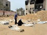 ナセル病院に埋葬された遺体の近くで嘆く女性＝パレスチナ自治区ガザ地区南部ハンユニスで2024年4月25日、ロイター