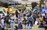 ニューヨークのコロンビア大で、テントを設営して抗議デモをする学生ら＝25日