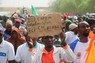 「ここはワシントンではない」などと書かれた紙を持って米軍の駐留に抗議するニジェールの市民＝同国の首都ニアメーで2024年4月13日、ロイター