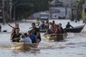 洪水被害に遭った地域からボランティアの助けで避難する人々＝ブラジル南部ポルトアレグレで2024年5月7日、AP